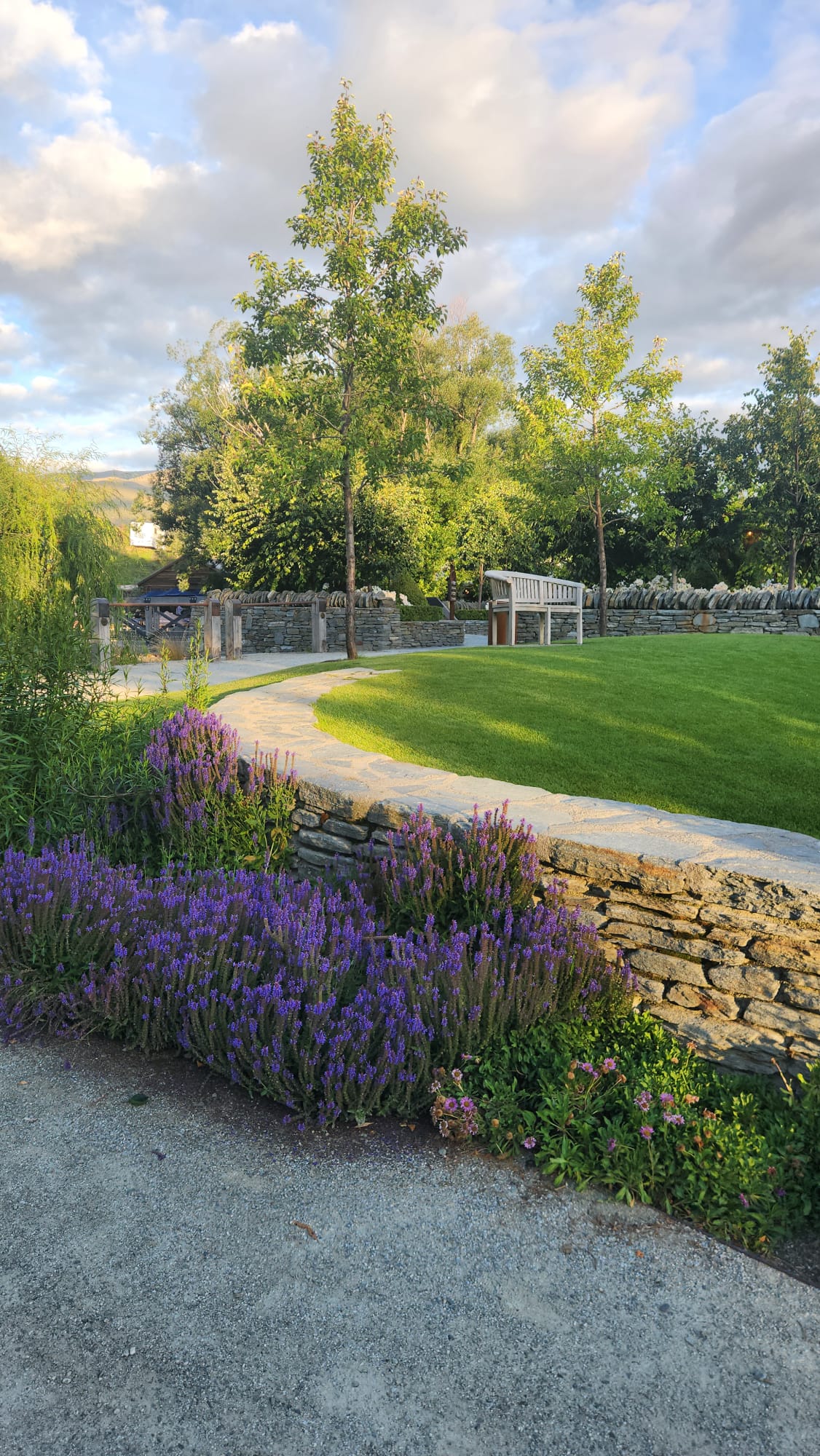 Gardens and stonework running down to the creek